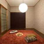 赤い絨毯と丸い照明のある板の間