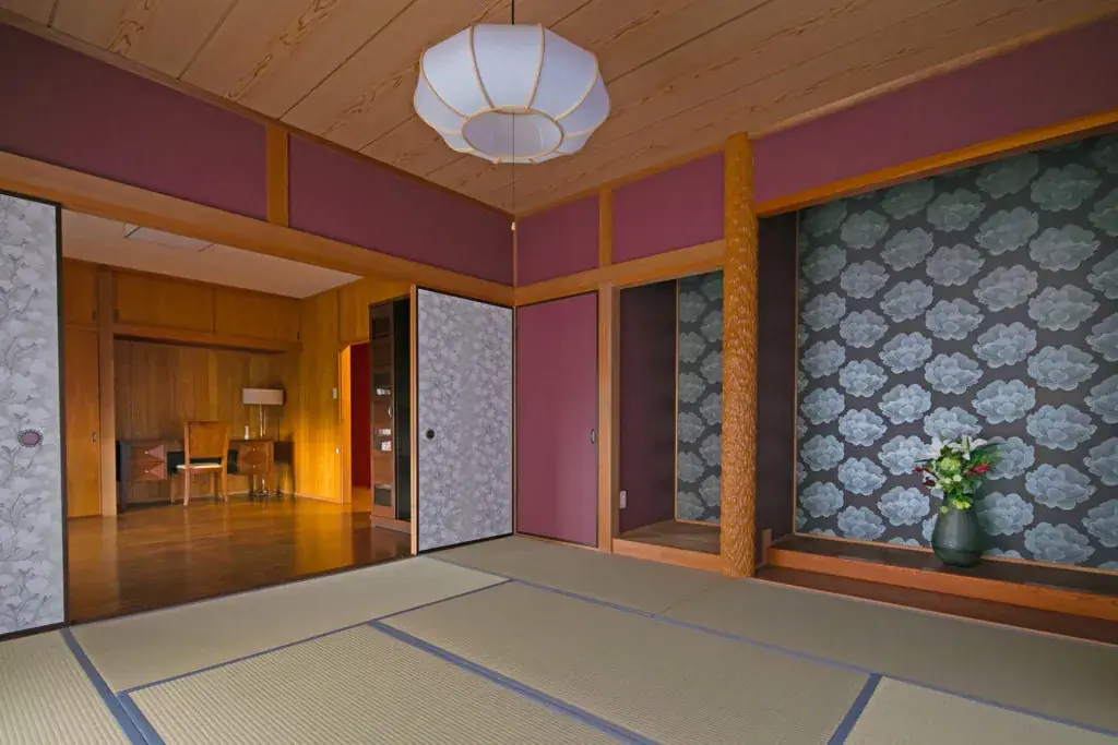 粋邑の和室。畳と障子、和紙の壁紙、吊り下げ照明のある部屋